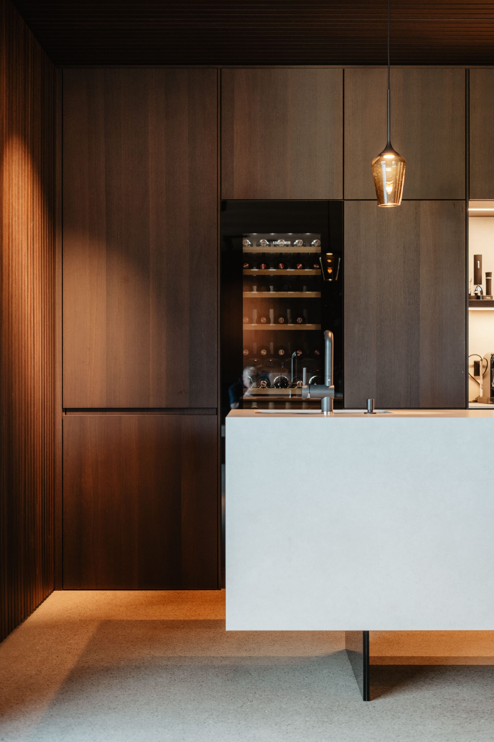 Küche mit Keramikinsel, dunkle Holzverkleidungen