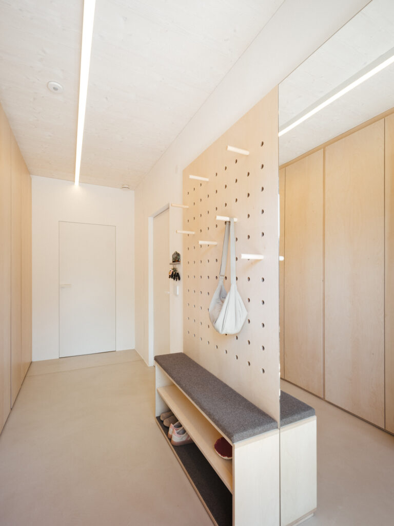 Garderobe in Birke mit Spiegel und Sitzmöglichkeit. Weiße Türen Wandbündig.